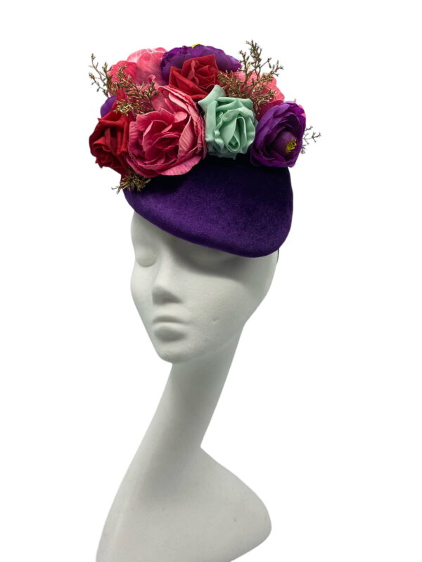 Purple velvet headpiece with an array of various coloured flowers.